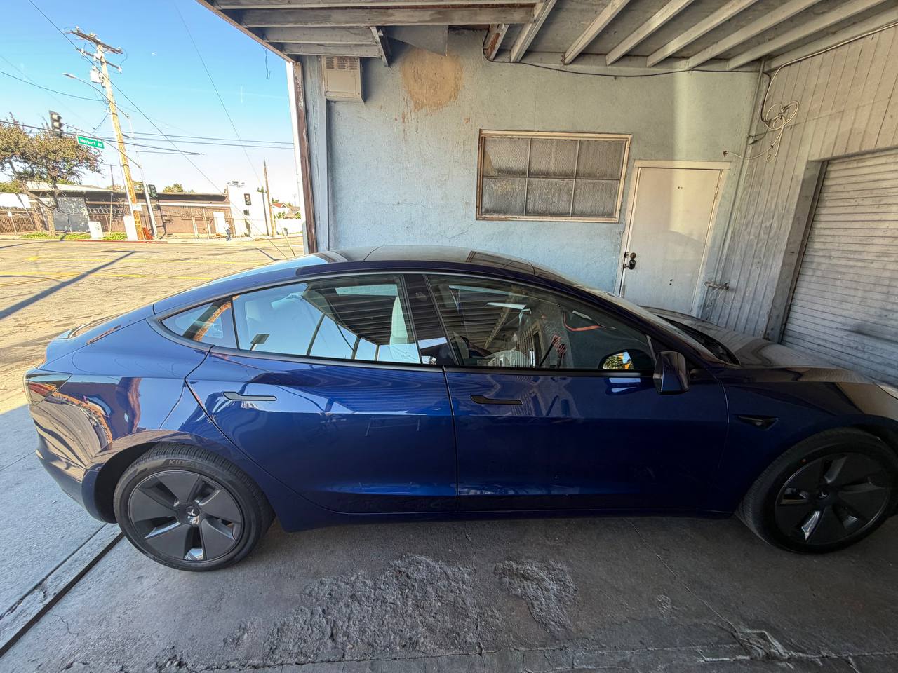 Blue Tesla Model 3 — before tint, side view